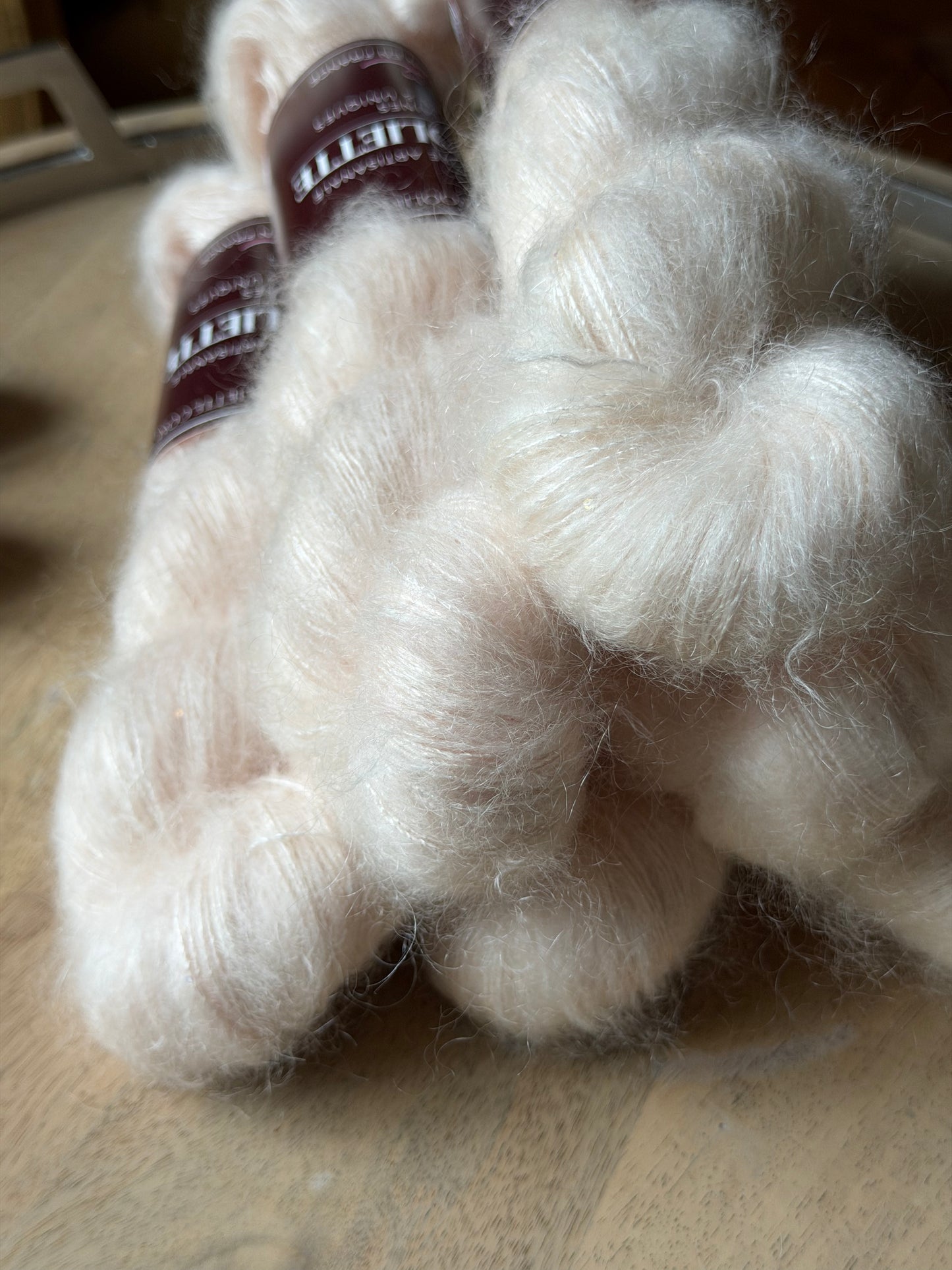 Fil super kid mohair rose très pâle presque ivoire, gros plan sur le halo et les paillettes, laine Aura Wooliette
