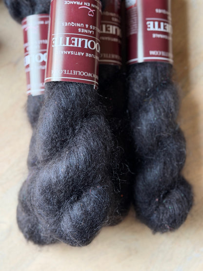Fil kid mohair noir à paillettes irisées roses et vertes, gros plan sur le halo, laine Aura Wooliette